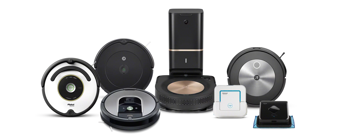 A family plays in the kitchen behind images of iRobot’s collection of robot vacuums and mops.