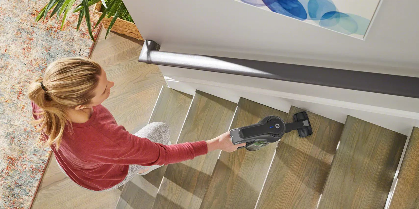 Lady vacuuming on the stairs