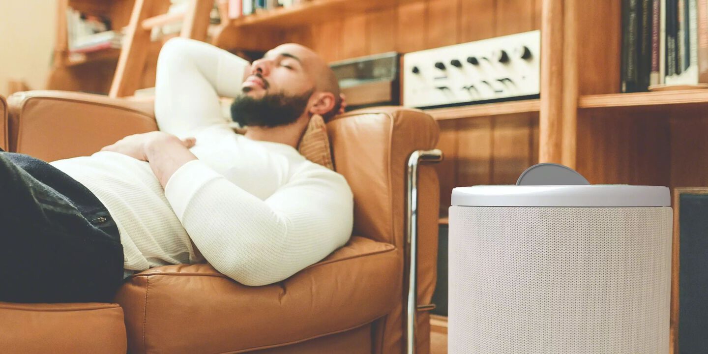 Man relaxing next to Aeris Air Purifier